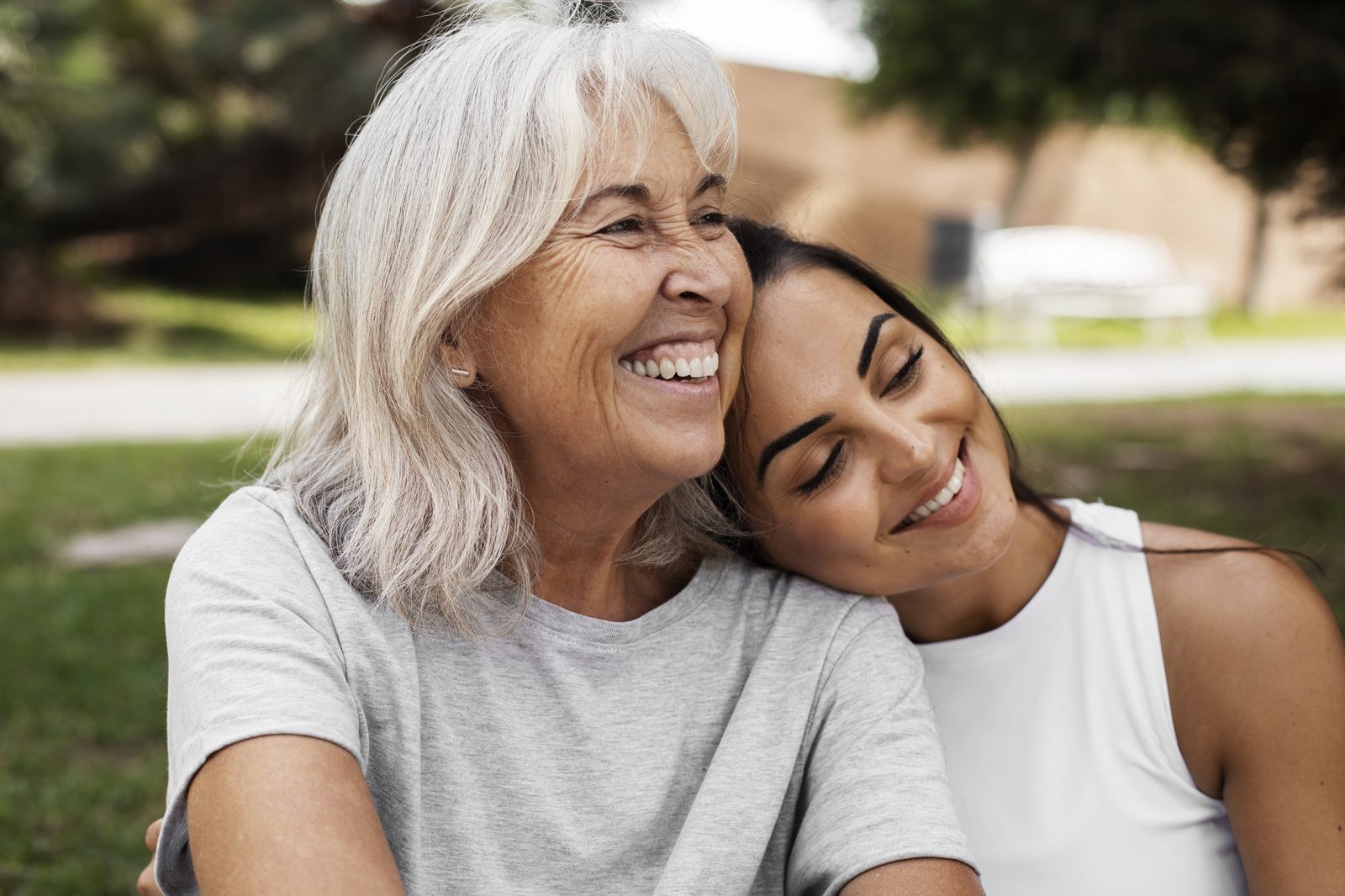 A grandmother and granddaughter laughing together outdoors