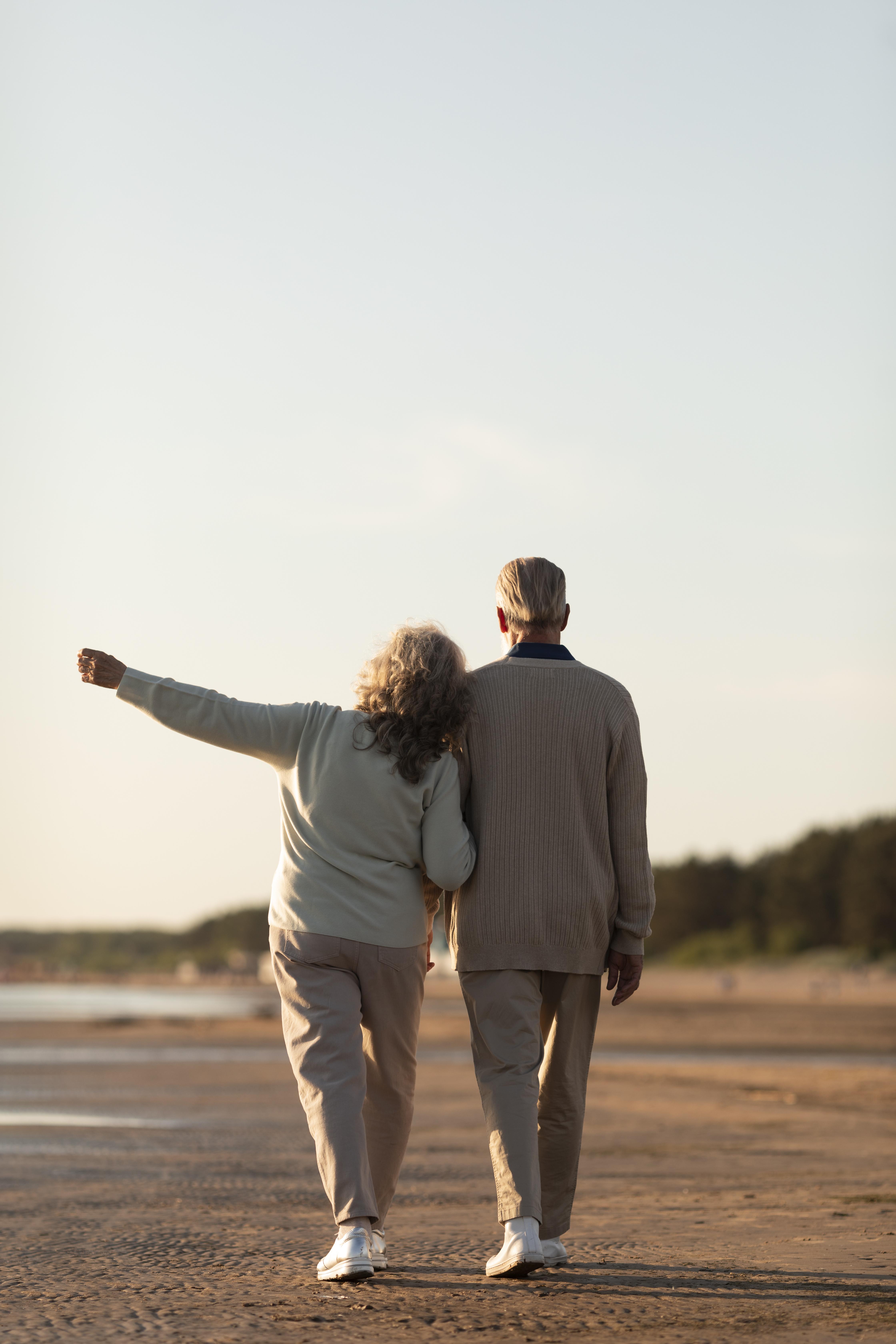A senior couple walking together along the seaside